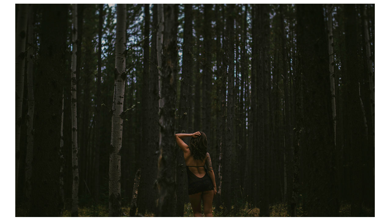 Girl standing in lingerie in forest