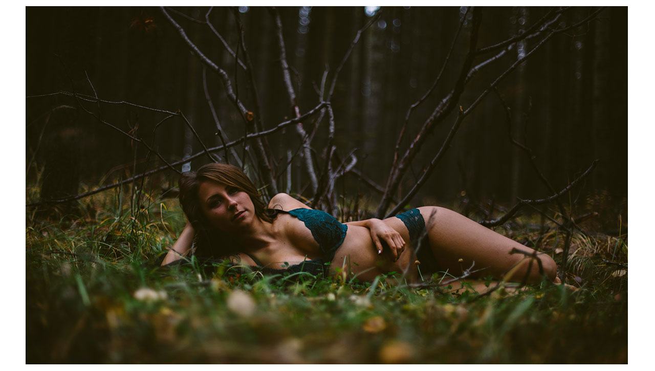 girl lying in lingerie on forest floor