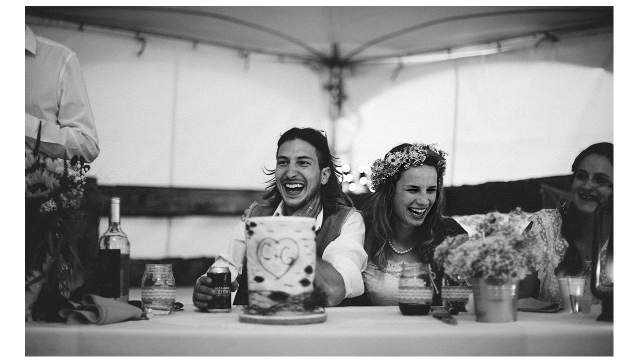Bride and groom laughing at reception